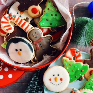 christmas icing cookies in a tin, a plate with more icing cookies