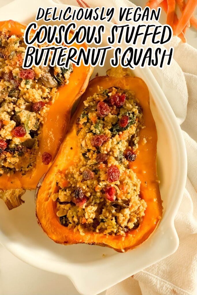 Two halves of cous cous stuffed butternut squash filled with a couscous stuffing featuring sautéed vegetables, leafy greens, and dried cranberries, presented on a white dish with a white and red-striped kitchen towel in the background, and a small red bowl of uncooked couscous nearby.