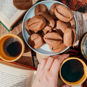 Coffee Bean Cookies Easy Recipe 2 close up, coffee bean cookies on a plate, two books on either side and coffee cups and napkins