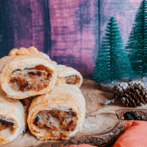 sausage rolls on a wooden board and a red napkin