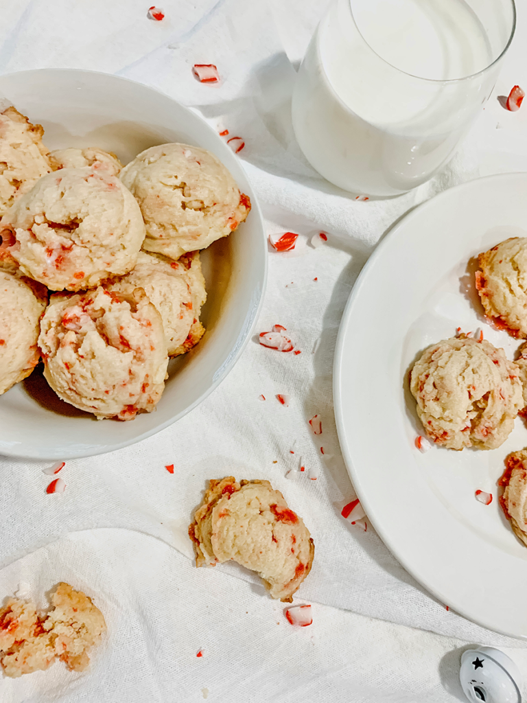 two plates of peppermint cookies, on a white napkin and a glass of milk