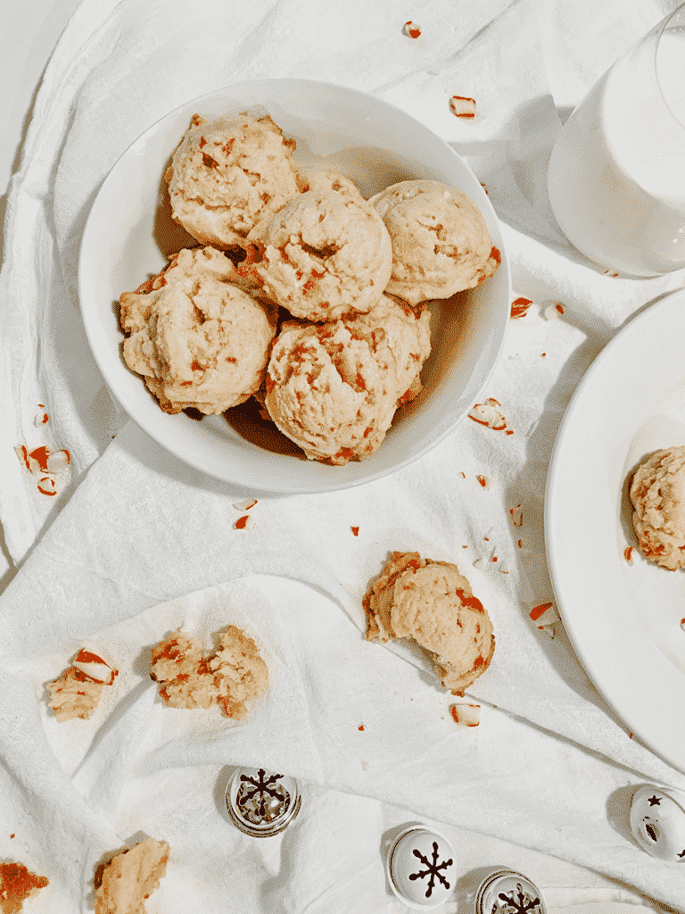 two plates of peppermint cookies, on a white napkin and more cookies broken on the side