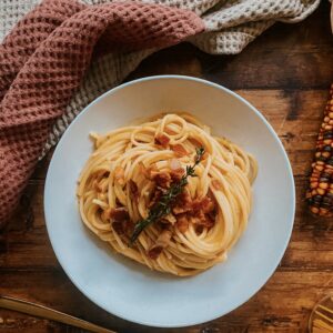 Creamy Butternut Squash Pasta With Crispy Bacon 2 butternut squash pasta with bacon on a plate, napkins on the side, corn