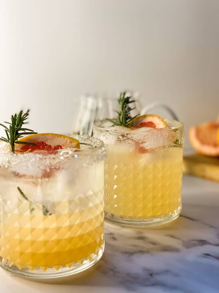 Easy Mocktail Recipes You Should Try 15 grapefruit mocktails in two cocktail glasses, jug with more behind- close up