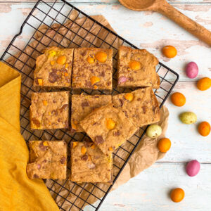 mini egg blondies on a cookie rack, mini eggs on the side