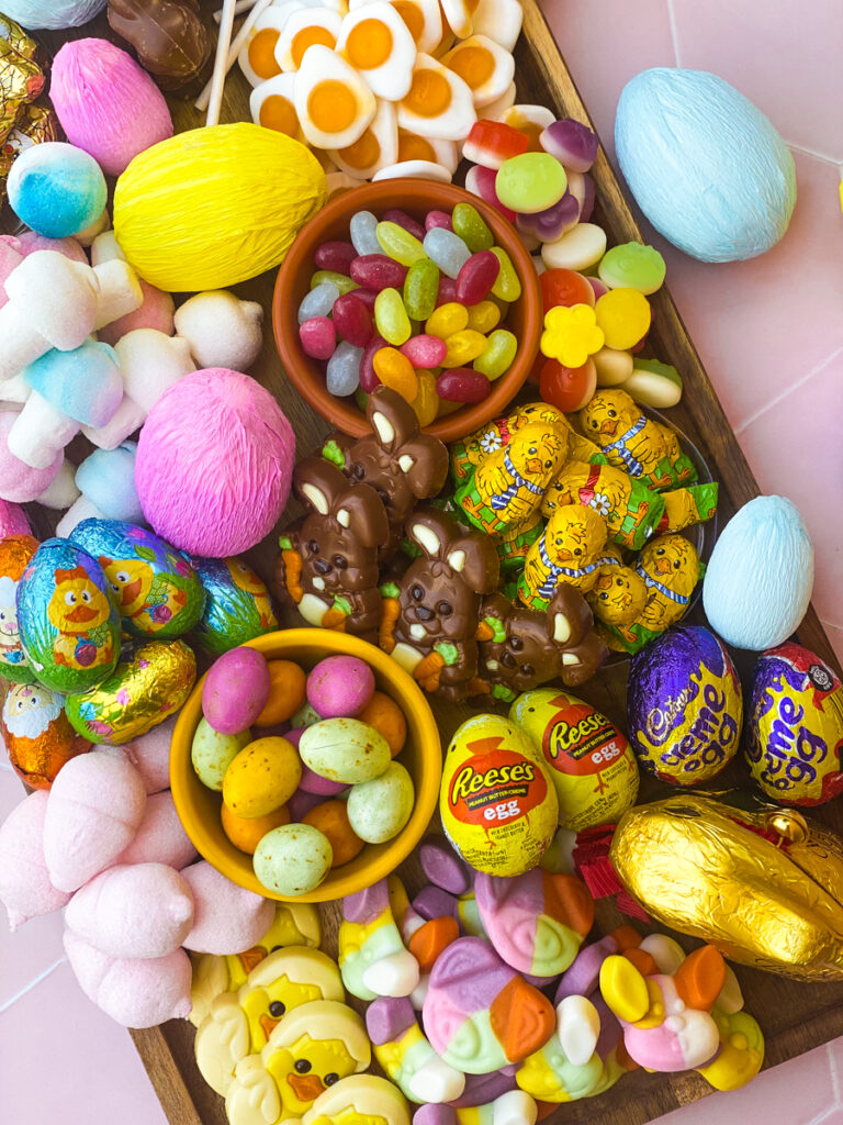 easter candy charcuterie board from above with paper covered eggs