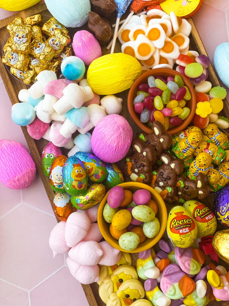 easter candy charcuterie board from above with paper covered eggs