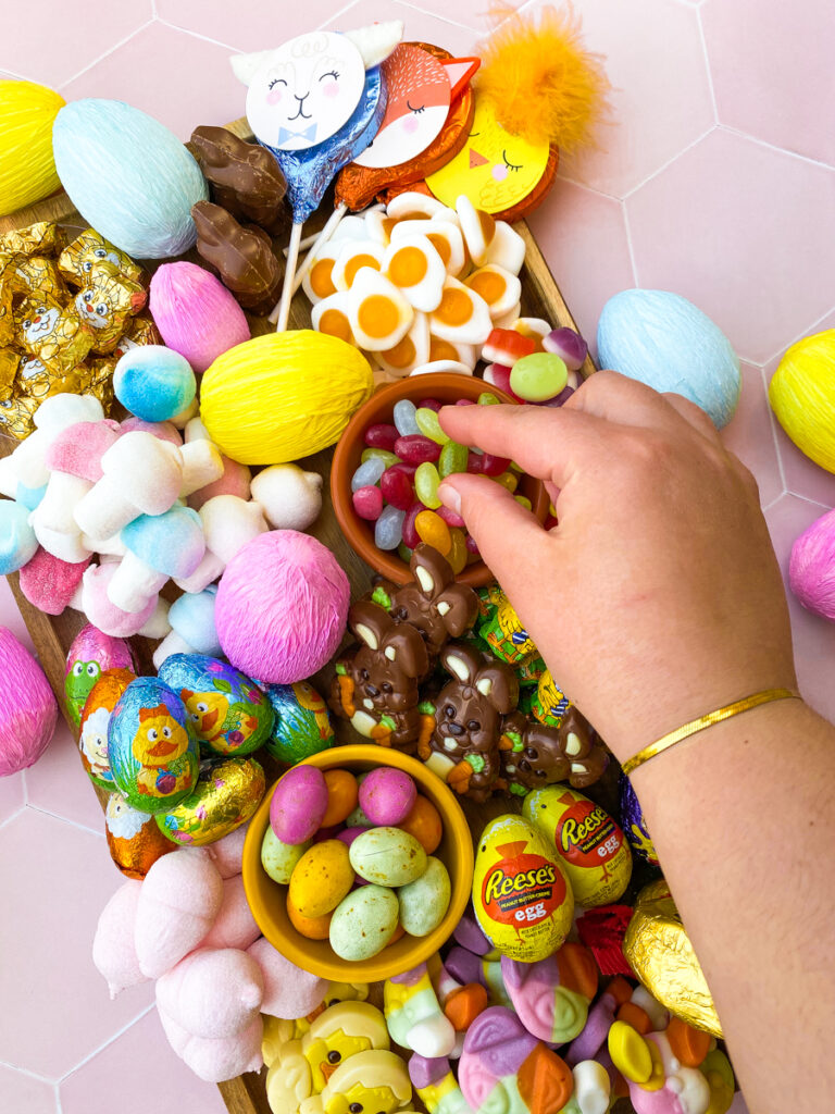 easter candy charcuterie board from above with paper covered eggs