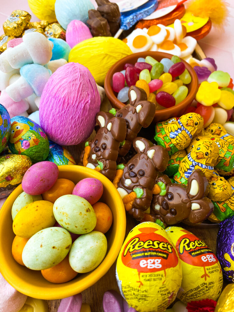 easter candy charcuterie board from above with paper covered eggs