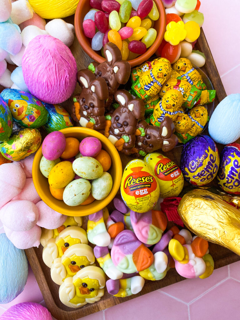 easter candy charcuterie board from above with paper covered eggs