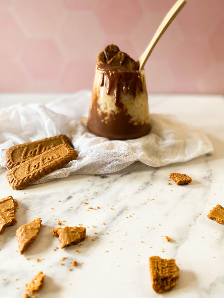 Deliciously Irresistible Biscoff Overnight Oats Recipe 6 the Biscoff overnight oats in a serving glass with garnish, on top of a white napkin and with lotus cookies around