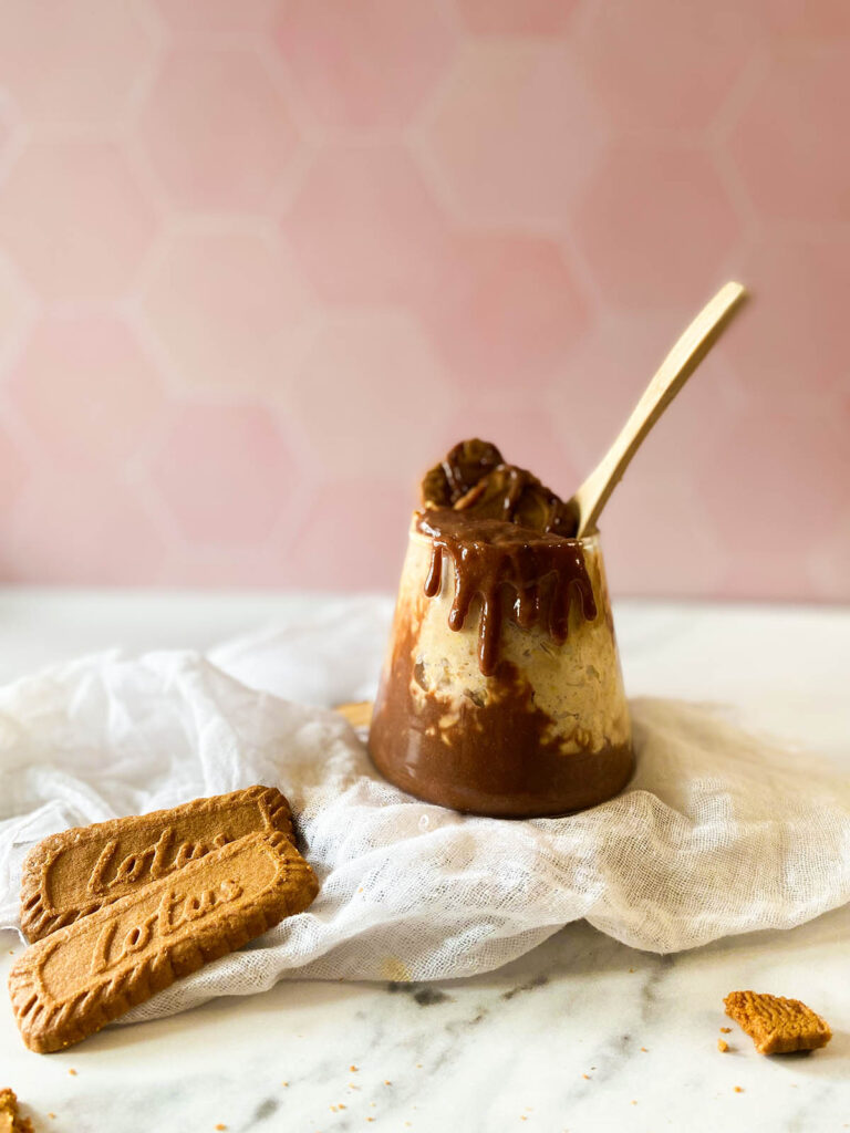 Deliciously Irresistible Biscoff Overnight Oats Recipe 1 the Biscoff overnight oats in a serving glass with garnish, on top of a white napkin and with lotus cookies around