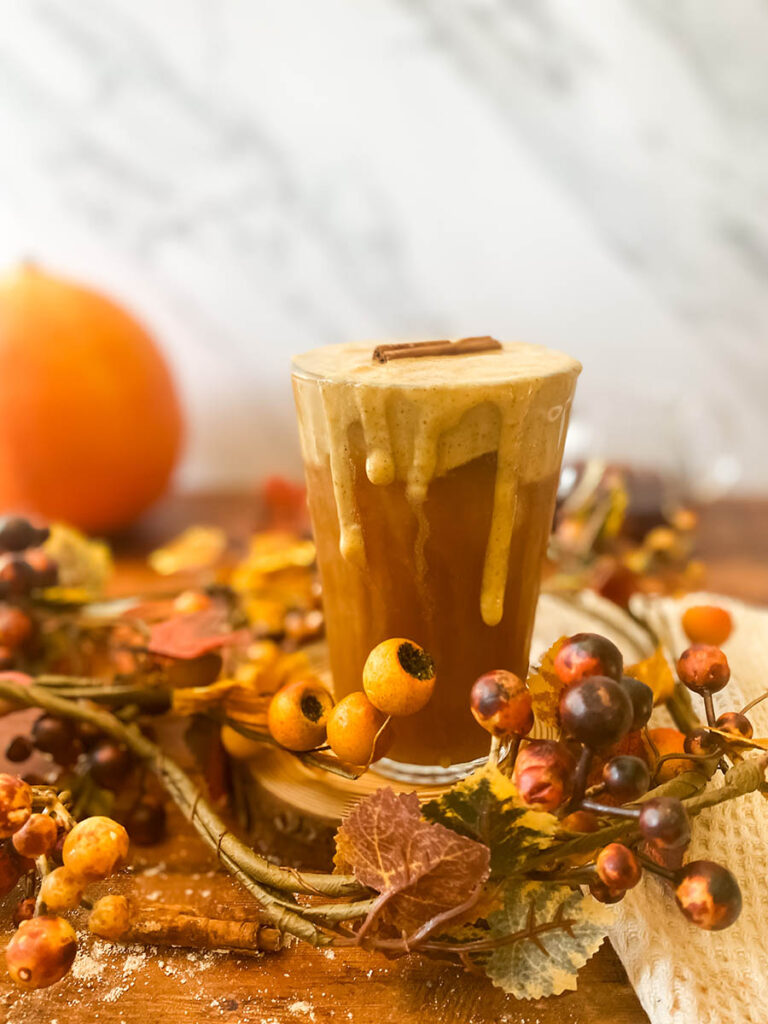 Ultimate Pumpkin Cold Foam Recipe, Starbucks Copycat 7 pumpkin cold foam recipe served over cold brew coffee with a brown glass straw and some elements recalling autumn all around