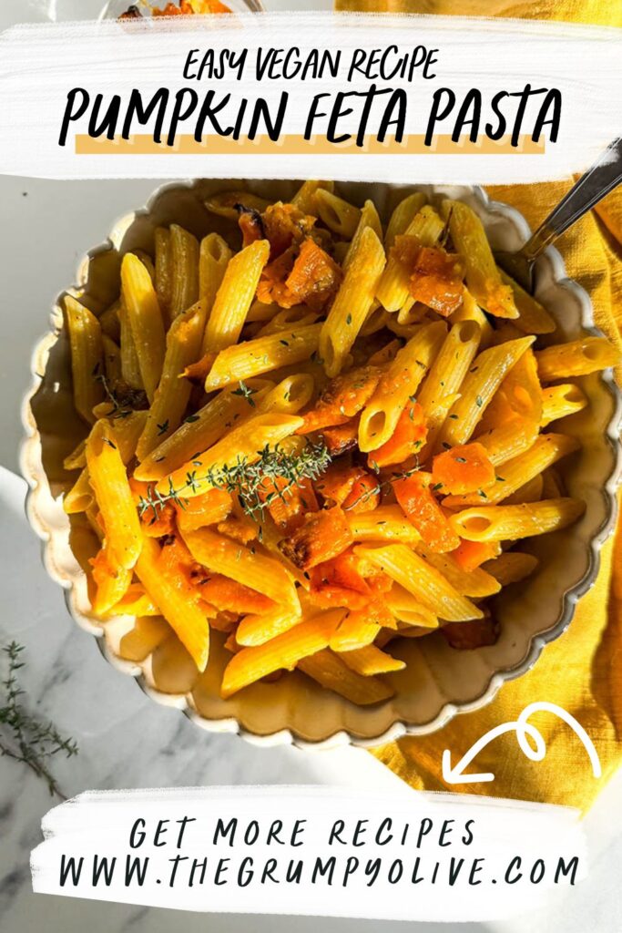 A promotional image for "Easy Vegan Recipe: Pumpkin Feta Pasta," showing a bowl of vegan pumpkin feta pasta garnished with herbs. Text overlay reads "Get more recipes at www.thegrumpyolive.com" with an arrow pointing to the link.