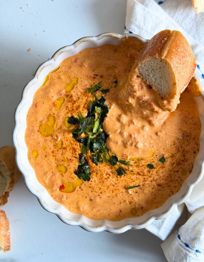from top, bowl of paprika dip in a bowl with bread and towel around