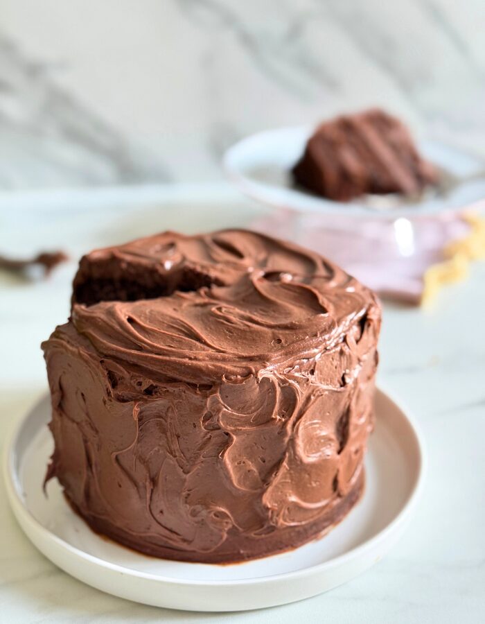 matilda's cake on a plate, a slice in the background, on a marble background