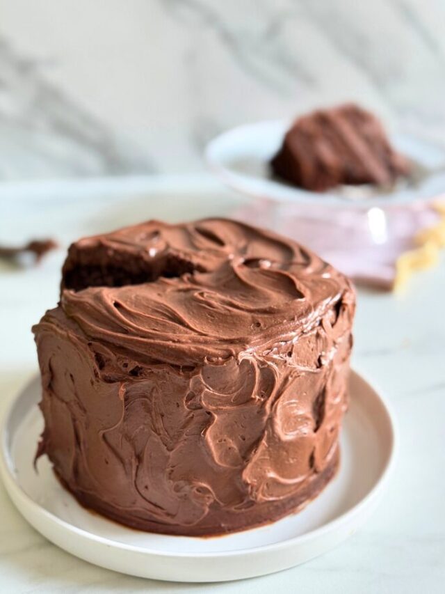 matilda's cake on a plate, a slice in the background, on a marble background