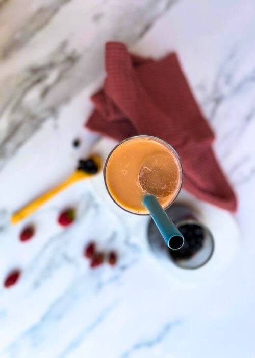Strawberry Milk Tea Recipe - Easy Strawberry Bubble Tea 4 a marble table background, a strawberry milk tea on a marble tray with a glass of boba