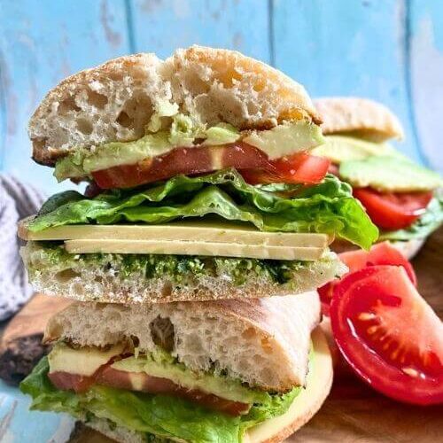 Violife Cheese Review From A Non-Vegan 6 cheese, avocado and tomato sandwich on a wooden board, on a blue wood background