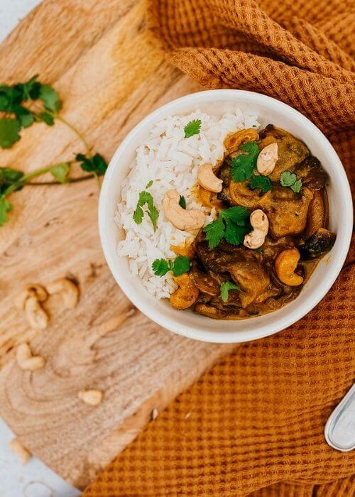 Vegan Mushroom Korma, The #1 Best Recipe 4 mushroom korma in a bowl, a napkin, wooden board and spoon, parsley on the side, close up