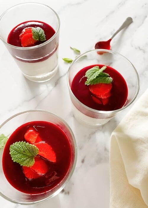 The Best Vegan Panna Cotta 1 vegan panna cotta in glasses on a marble background, a spoon and mint leaves on the side, towel on the side