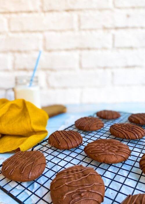 close up of a cookie rack with nutella cookies, napkin and glass on the background