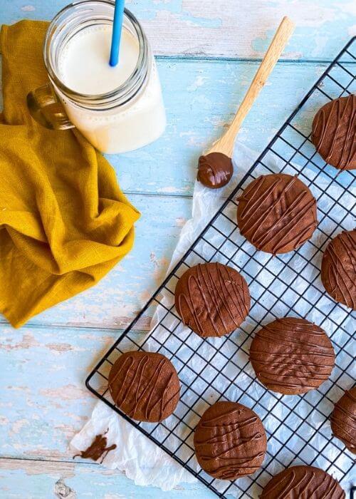 from above, cookie rack with nutella cookies, napkin and glass of milk, spoon nutella