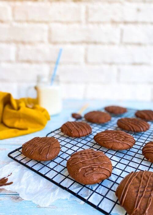 close up of nutella cookies on a rack, napkin and glass of milk on the background