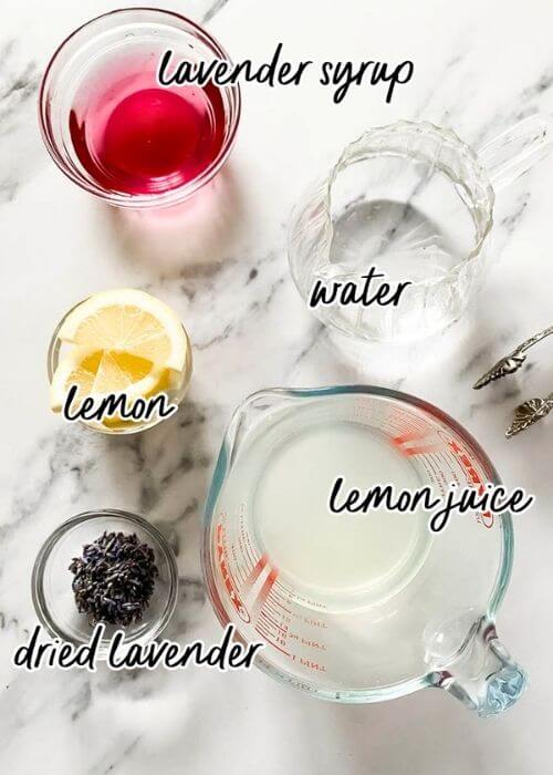 Delicious Lavender Mocktail, Easy To Make 2 ingredients for lavender mocktail recipe in bowls and pitchers on marble background